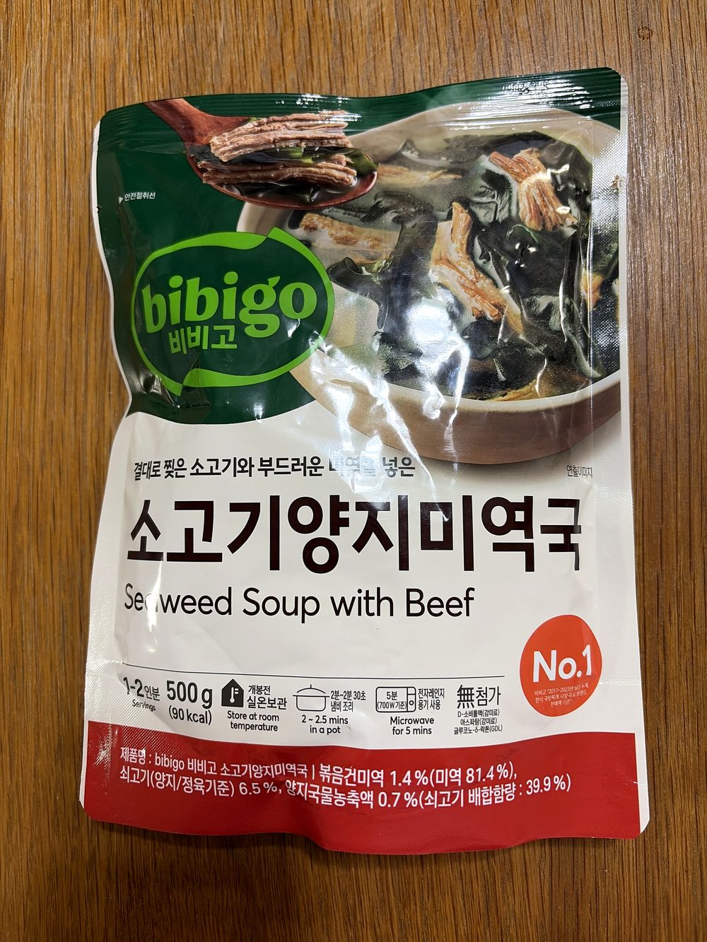A 500g pouch of CJ Bibigo instant seaweed soup with beef on a wooden kitchen table