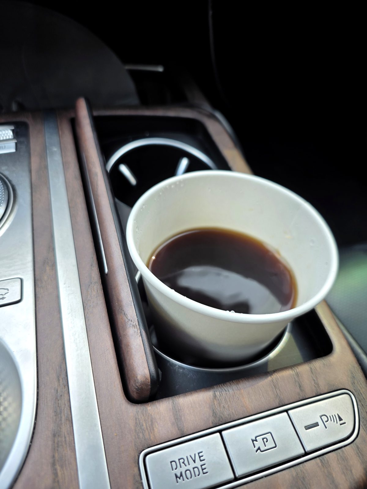 Paper cup of black instant coffee sitting in a car cupholder on the morning commute in Seoul